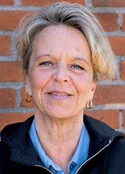 Kristina person framför tegelvägg.