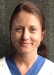 Porträtt Karin Hallin med mörkt hår och bussarong av sjukhusmodell.