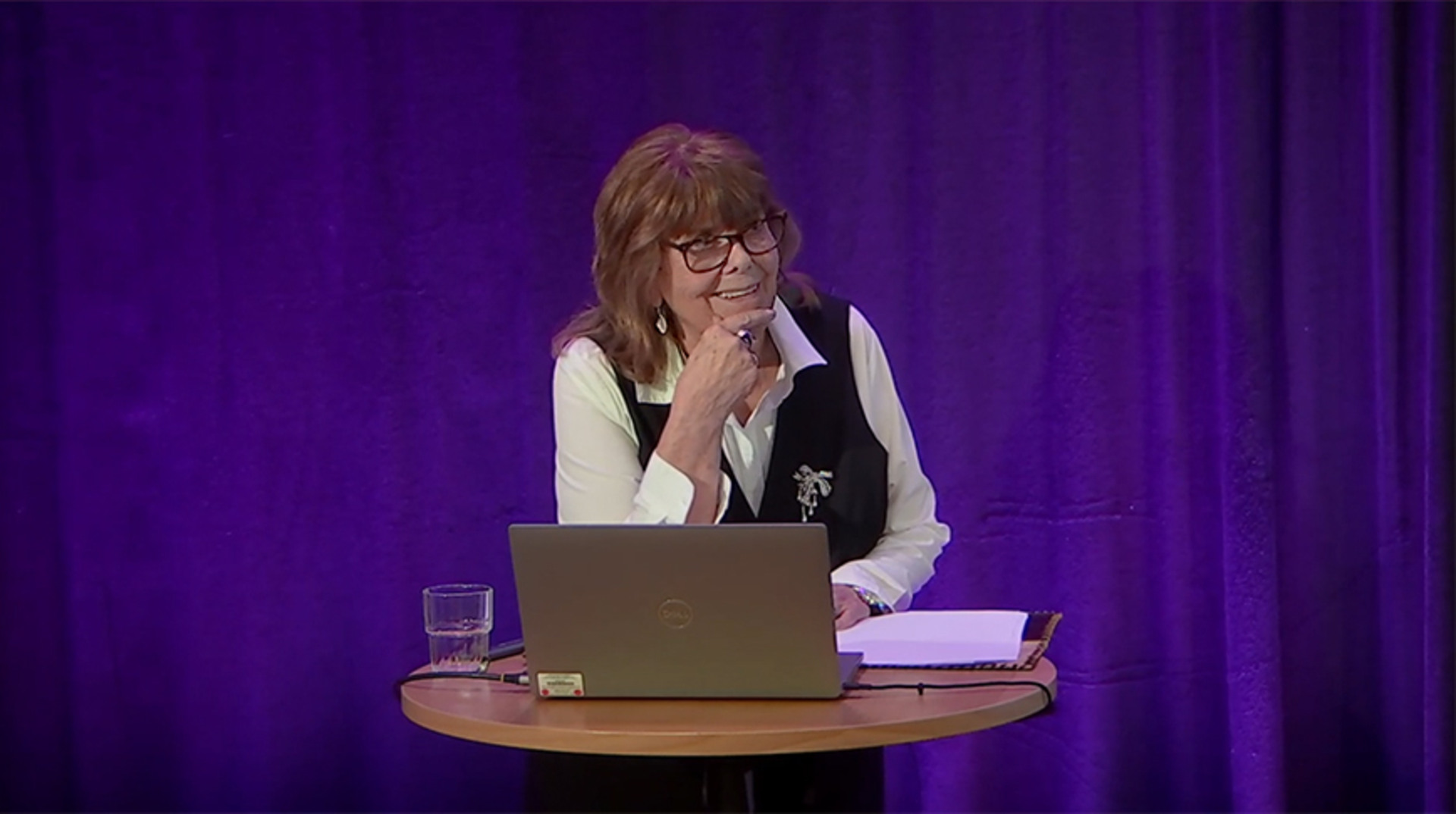 Maud Deckmar framf&ouml;r violett bakgrund vid f&ouml;rel&auml;sardator.