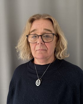 Portr&auml;ttbild p&aring; Anna Wikstr&ouml;m. En kvinna med blond, v&aring;gig page och glas&ouml;gon som tittar in i kameran.