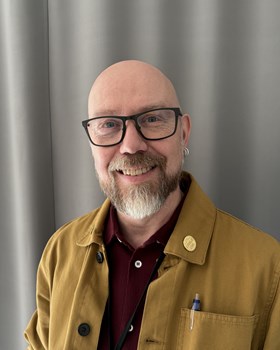 Portr&auml;ttbild p&aring; Hans Wennerberg. En man med sk&auml;gg och glas&ouml;gon som ler mot kameran.