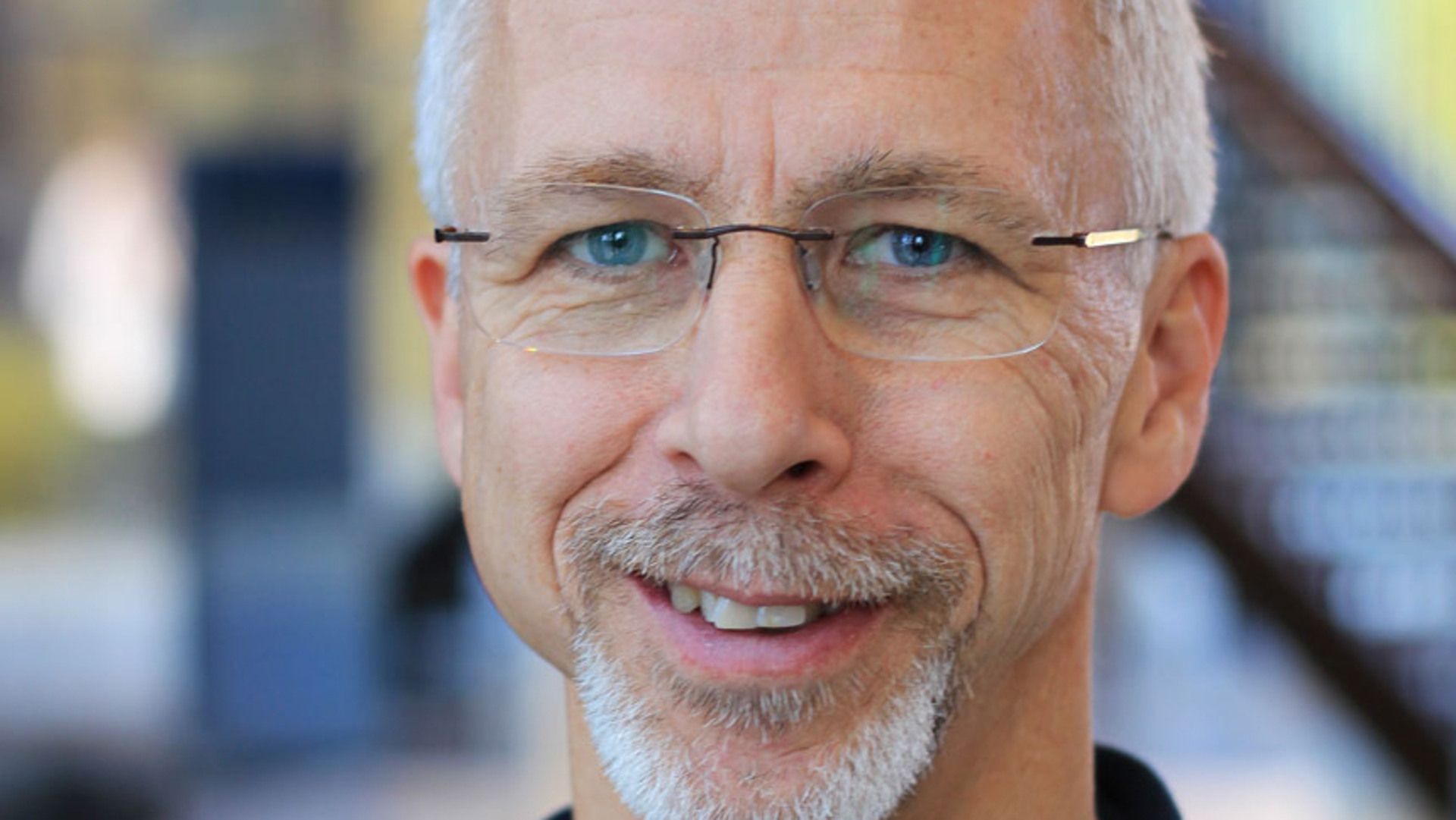 N&auml;rbild p&aring; leende Magnus P&aring;hlmans ansikte. Han har mustasch,  gr&aring;tt kort h&aring;r och sm&aring; ramfria glas&ouml;gon.