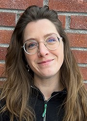 Porträttbiöd Anna Bergman framför tegelvägg.