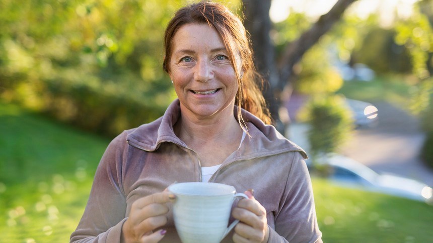 Kvinna med tekopp i händerna utomhus