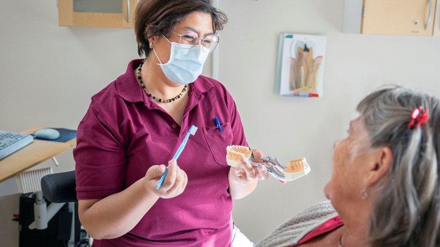 Kvinnlig personal instruerar manlig patient