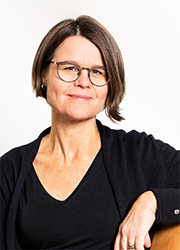 Porträttbild Anna Ehn, i mörk långärmad topp, mörkbrunt hår och glasögon.