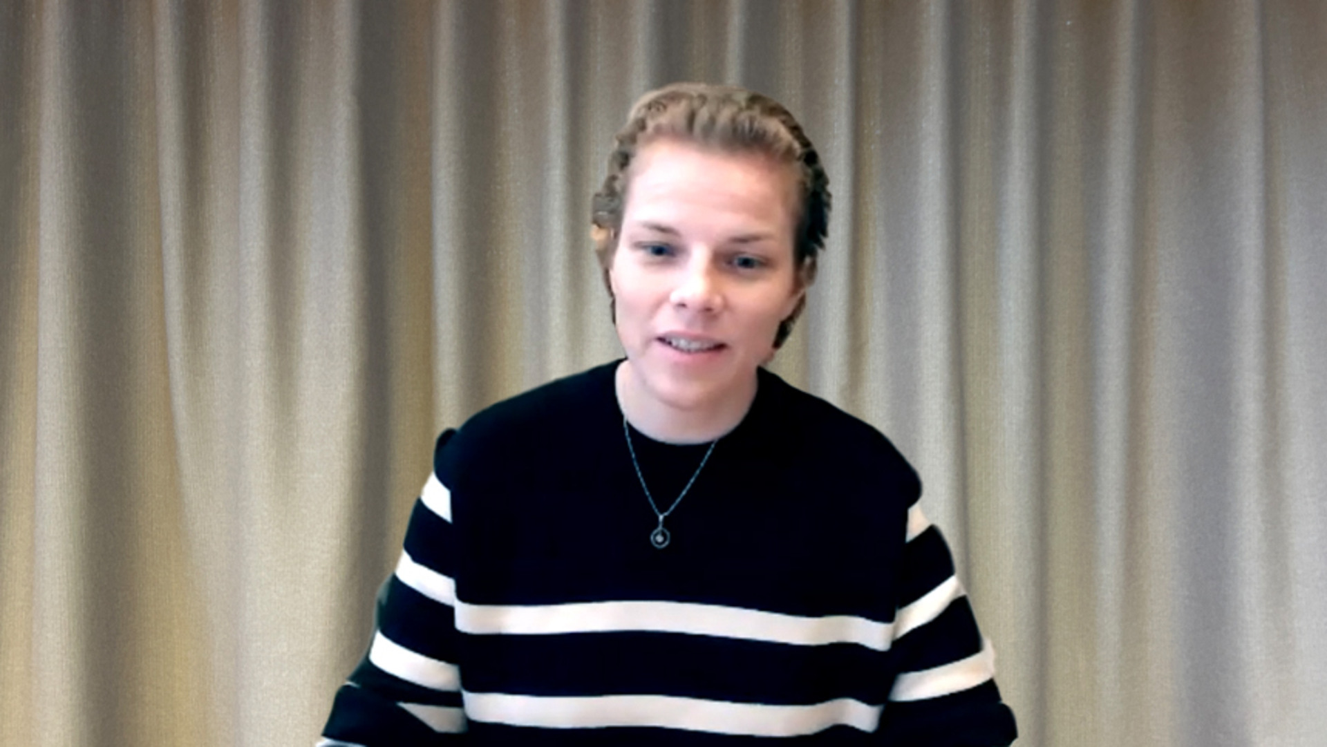 Lisa Dinkler i randig tr&ouml;ja framf&ouml;r gr&aring;tt draperi.