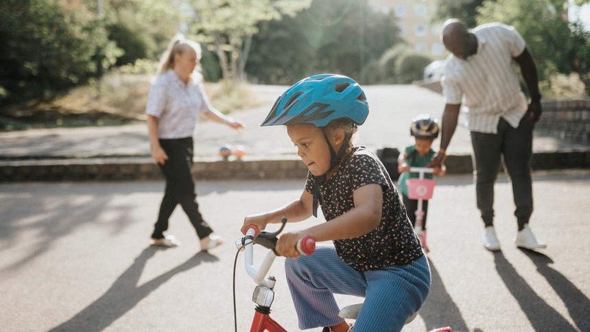 Ung man bredvid cykel omgiven av människor