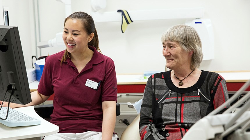 Kvinnlig patient och tandsköterska i samtal