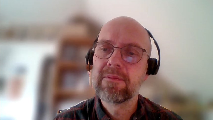 Gerhard Andersson föreläser framför datorn. Han har hörlurar på sig.