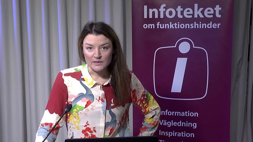 Ingrid Lundberg föreläser. Bredvid syns en vepa med texten infoteket om funktionshinder.