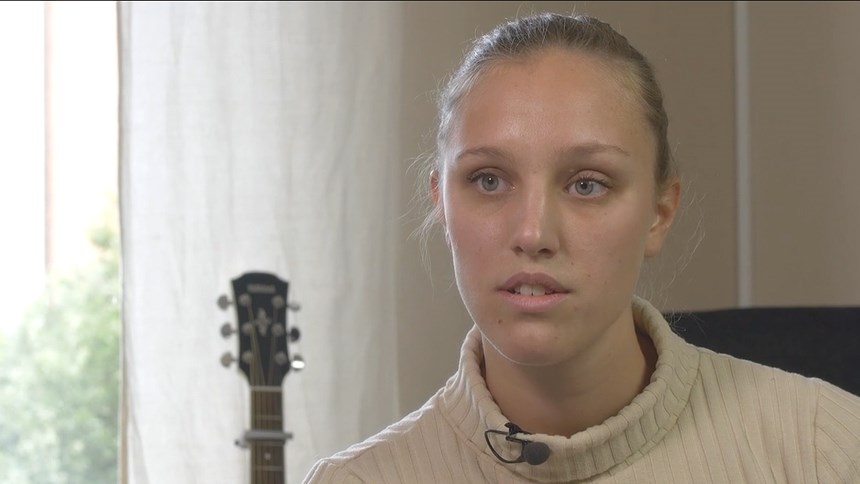 Bildklipp från filmen om bipolär sjukdom. Siri och bakom henne en gitarr som står mot väggen. 