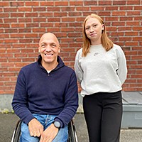 Niklas och Louise framf&ouml;r r&ouml;d tegelv&auml;gg