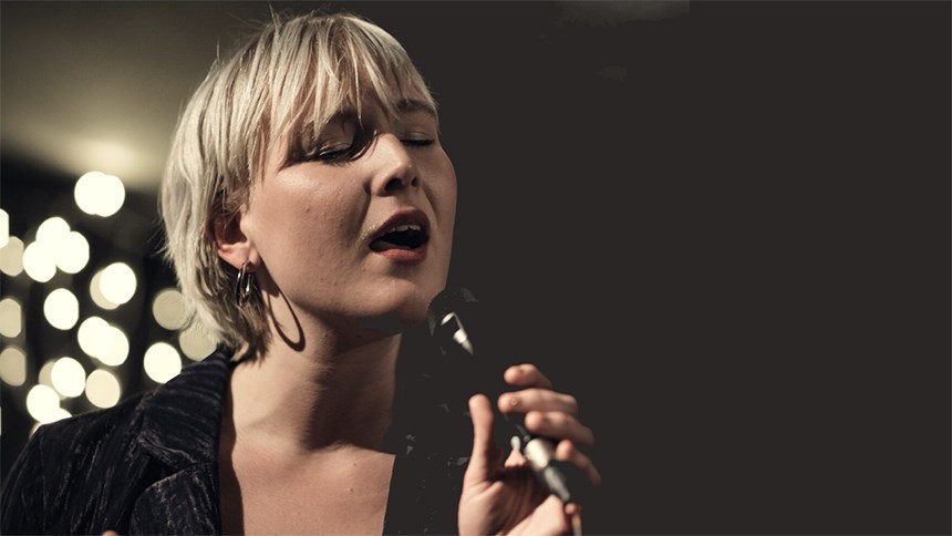 En kvinna som sjunger i en mikrofon 