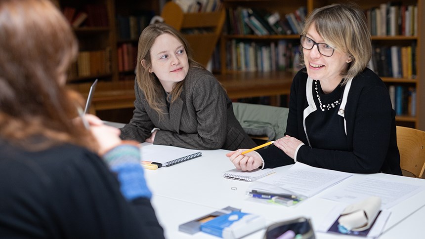 Tre personer sitter runt ett bord