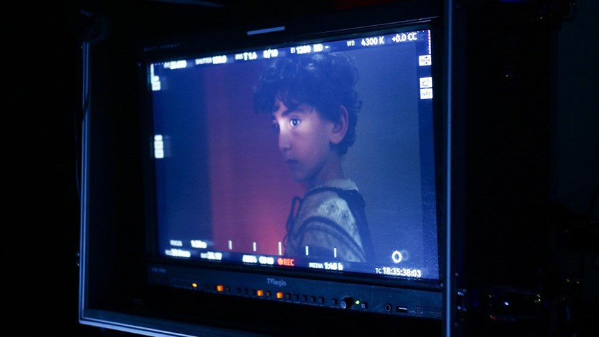 Fota av en filmduk som visar en pojke med mörkt lockigt hår. 