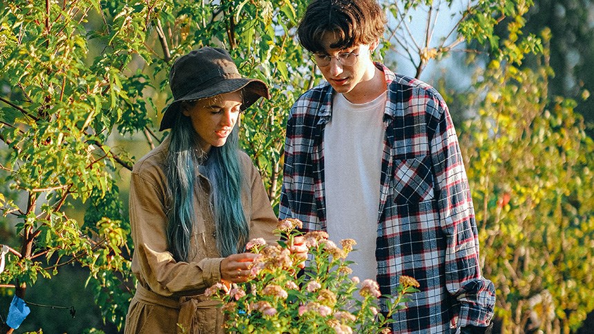 Två unga människor jobbar i trädgård