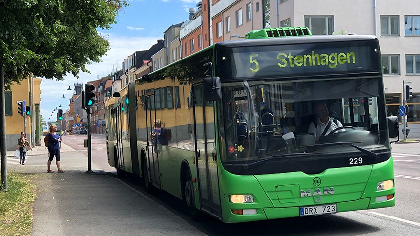 Grön stadsbuss i trafiken