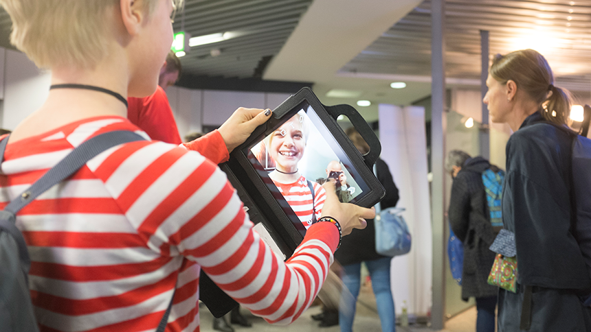 Ett barn som ler mot en i-pad