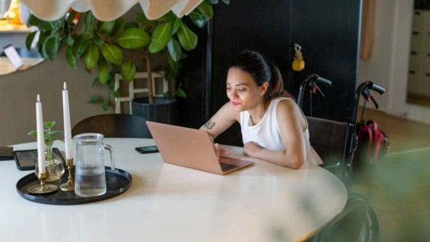 Kvinna sitter vid ett bord framför en dator