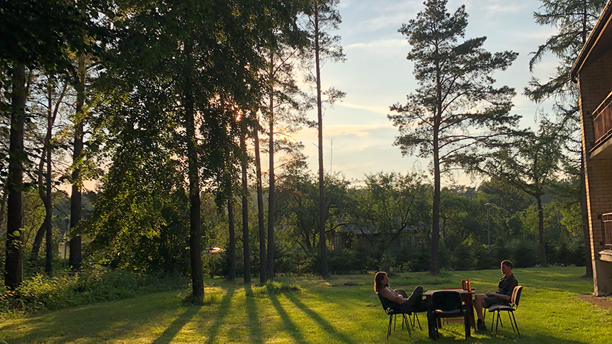 Två personer sitter vid ett bord i naturen