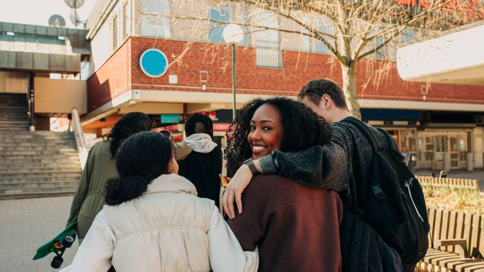 Ungdomar håller om varandra utanför en skola